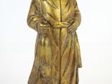bronze statue of a woman with a cane standing on a block