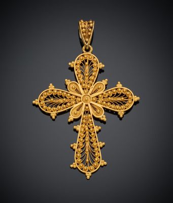 un pendentif en forme de croix dorée sur fond noir