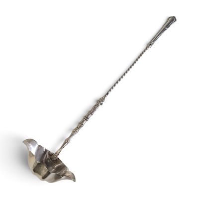 une cuillère en argent avec un manche sur une surface blanche