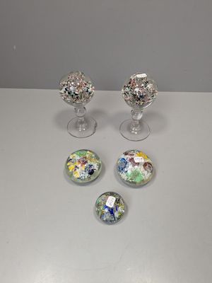 quatre boutons en verre aux motifs variés, posés sur une table