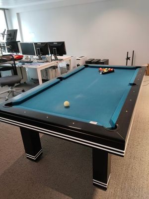 une table de billard avec une boule dessus, dans une pièce