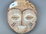 une image représentant un masque en bois sur lequel est accrochée une étiquette