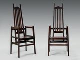 deux chaises en bois assises l'une à côté de l'autre sur une surface blanche