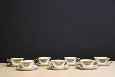 six tasses et soucoupes sont alignées sur une table