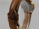 a close up of a watch with a brown leather band