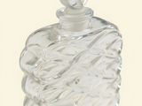 a clear glass bottle with a silver top on a white surface