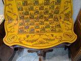 une table jaune sur laquelle est posé un échiquier