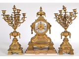 une horloge dorée et trois lustres sur fond blanc