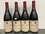 quatre bouteilles de vin sont alignées sur une table