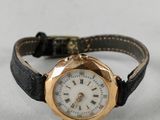 une image d'un gros plan d'une montre-bracelet sur une surface blanche