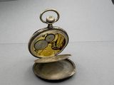 a silver pocket watch sitting on top of a table