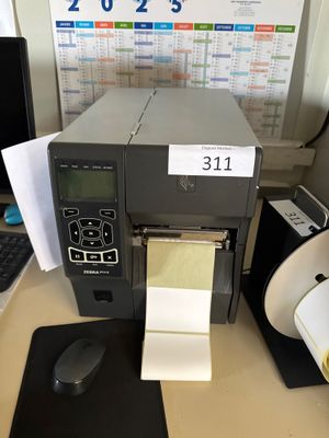 une imprimante posée sur un bureau à côté d'un ordinateur