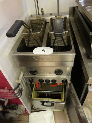 une photo d'une cuisine où l'on voit de nombreuses friteuses