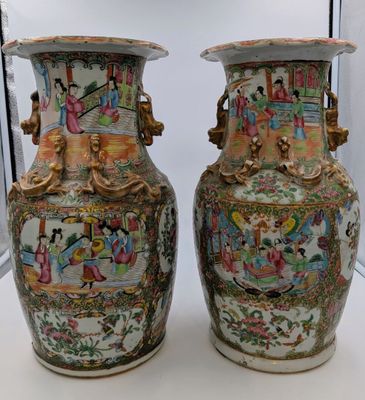 pair of chinese vases on display in a glass case