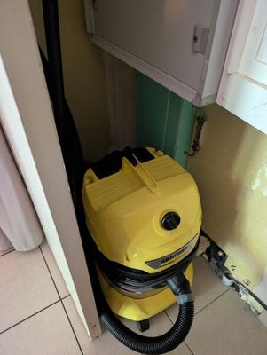 un aspirateur jaune posé dans un coin de la pièce