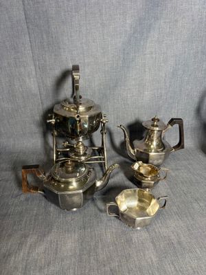 trois théières en argent et deux tasses en argent sur fond gris