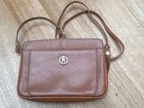 a brown purse sitting on top of a wooden floor next to a wooden floor