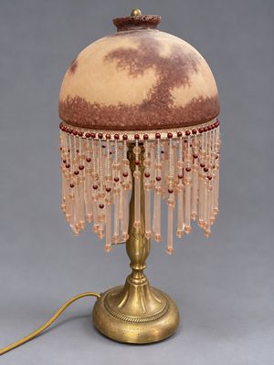 une photo d'une lampe de table avec un abat-jour en verre et un abat-jour orné de perles