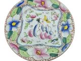 a decorative plate with flowers on it on a white background