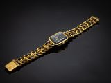 un gros plan d'une montre-bracelet en or sur fond noir