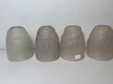 four vases are lined up in a row on a white surface