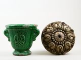 a green vase next to a green vase on a white surface