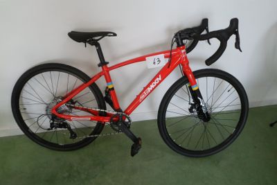 un vélo rouge appuyé contre un mur blanc