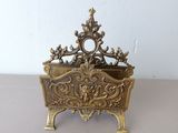 gold plated metal planter with ornate design on top of a table