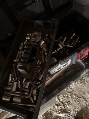 a box of tools sitting on the floor next to a pile of dirt