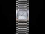 a close up of a silver watch on a black background