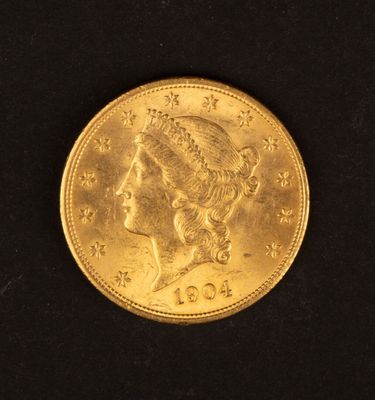 gros plan d'une pièce d'or sur une surface noire