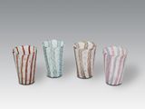 quatre vases en verre de couleurs différentes placés les uns à côté des autres