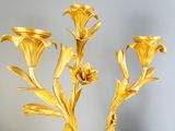 a gold vase with flowers in it on a table