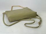 beige leather handbag with gold chain strap on white background