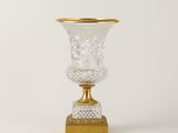 un vase en verre à bord doré posé sur une table