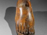 an image of a wooden shoe with a foot sticking out of it ' s sole
