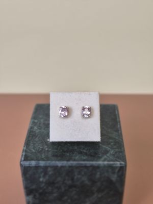 a close up of a pair of earrings on top of a marble block