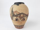 a small vase with a picture of a house on it