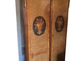 a tall cabinet with two doors and a basket on top of it
