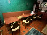 des tables et des chaises dans une pièce aux murs verts et au sol carrelé