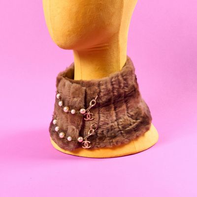 une tête de mannequin portant un col en fourrure orné de perles