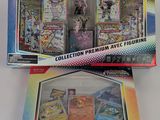 Deux boîtes de cartes à collectionner Pokémon sont posées sur une table.