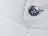 the back of a white dress with a button on it