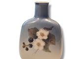 un vase bleu orné de fleurs blanches sur fond blanc