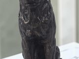 une statue représentant un chien assis sur une table