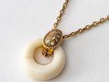 an image of a white and gold necklace with a lion head on it