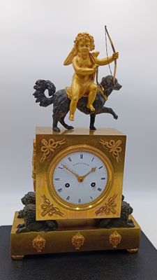 une horloge en or surmontée d'une statue représentant un homme à cheval