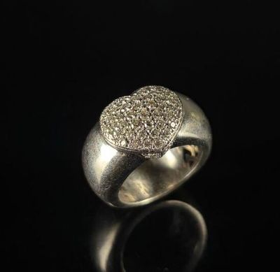 a close up of a silver ring with diamonds on a black surface