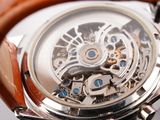 a close up of a watch with a brown leather strap