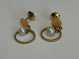 gros plan d'une paire de boucles d'oreilles sur une surface blanche
